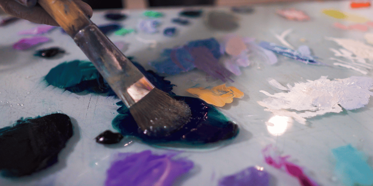 Paintbrush dipping into oil paint