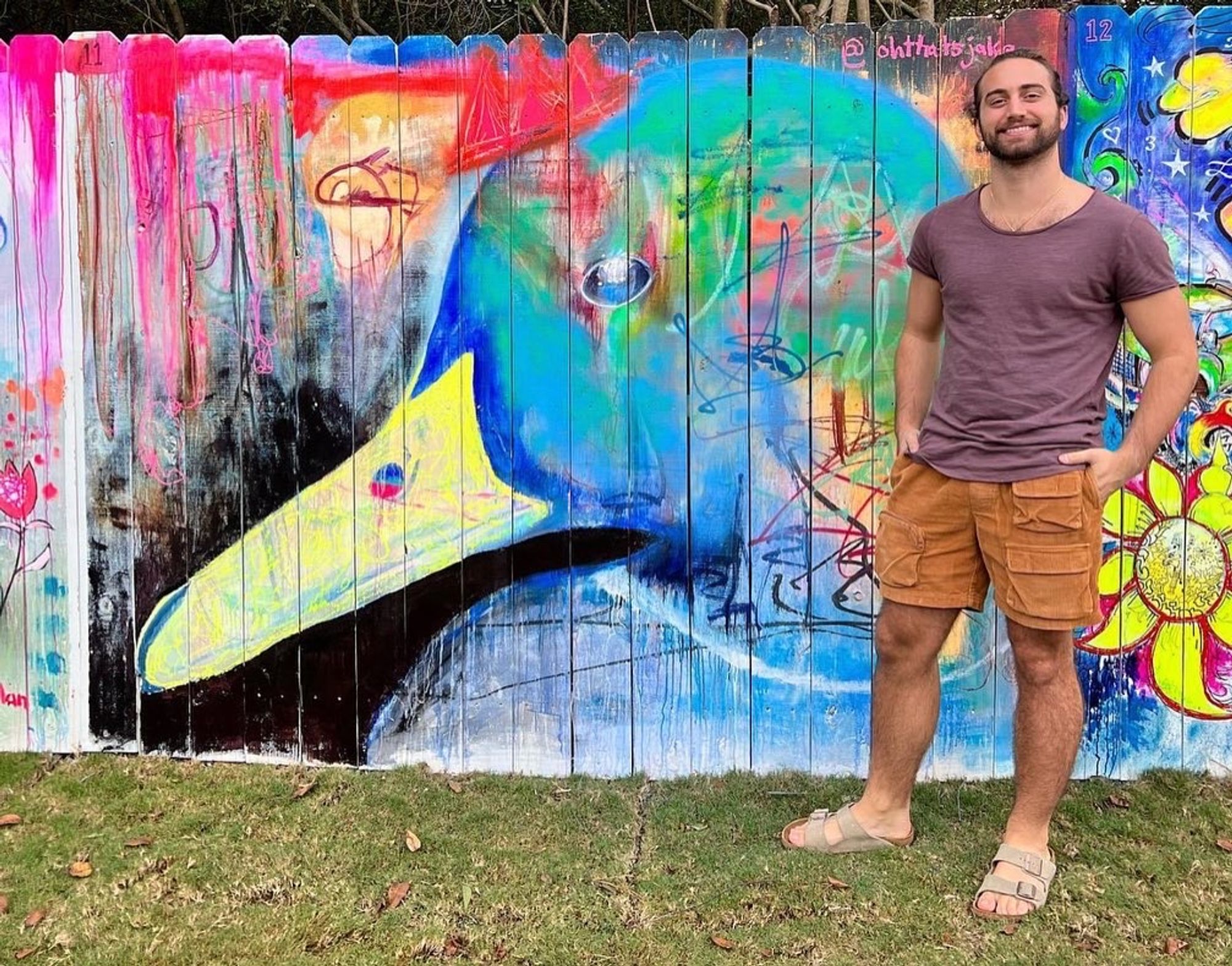 Jake Dunn in front of acrylic paint wall mural